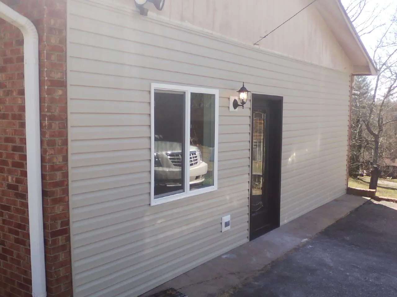 New vinyl siding and entry door on a room addition in New York Mills